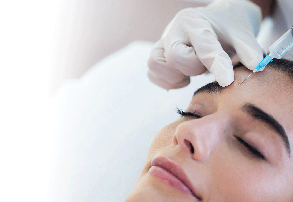 Woman receiving aesthetic injectables from a nurse practitioner in her forehead